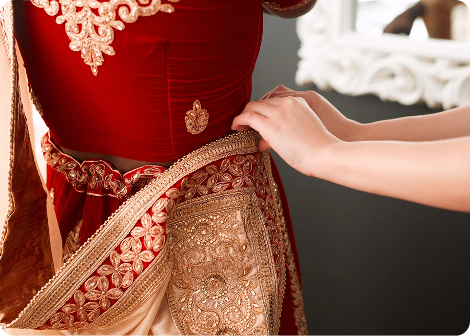 Adjusting red and gold ornate dress.